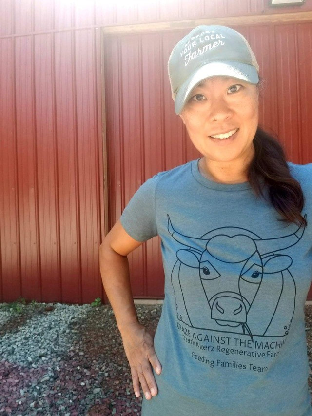 A young lady wearing a cap and a blue Graze Against The Machine t-shirt