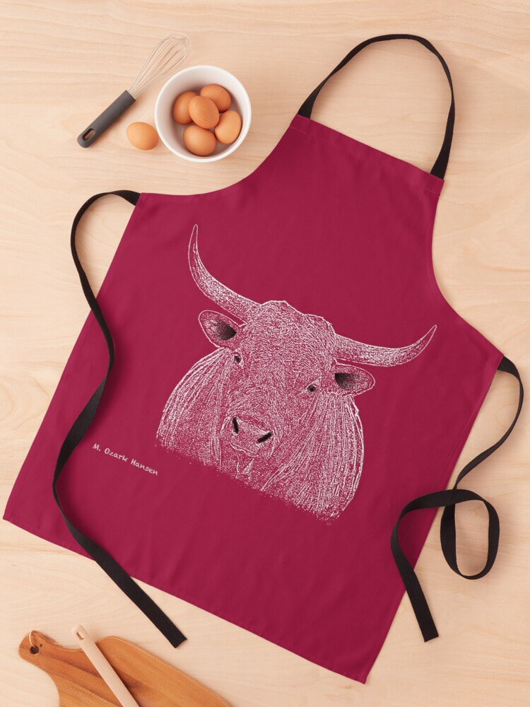 Red apron with a white sketch of Rocky the bull lying on a kitchen counter